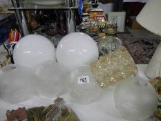 A quantity of glass lampshades and an oil lamp base (collect only)