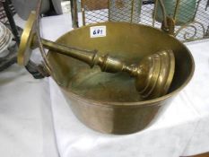 A Victorian brass jam pan and a candle holder.