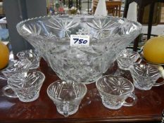 A punch bowl with glasses.