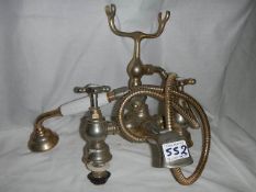 A set of old brass bath taps with shower attachment.