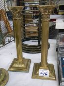 A pair of brass Corinthian column candlesticks.
