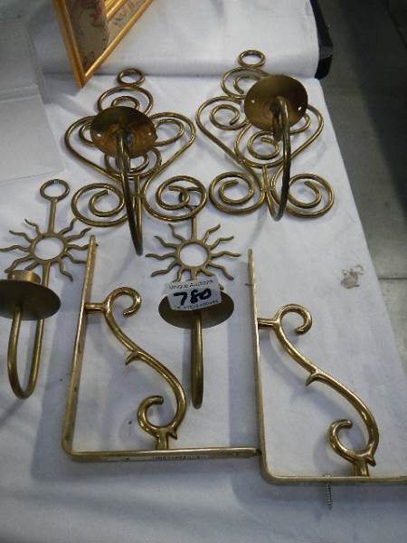 Two pairs of brass wall candleholder and two brass brackets.