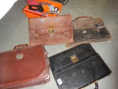 Three old leather briefcases and a modern case.