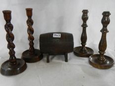 Two pairs of wooden candlesticks and a barrel shaped box.