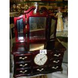A jewellery box with clock containing an assortment of costume jewellery.