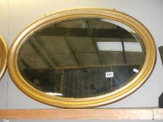 An oval gilt framed bevel edged mirror.