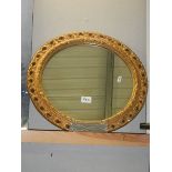 A circular gilt framed mirror.