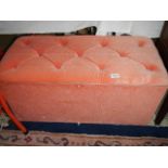 A pink dralon ottoman.