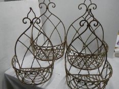 Four metal wall hanging baskets.