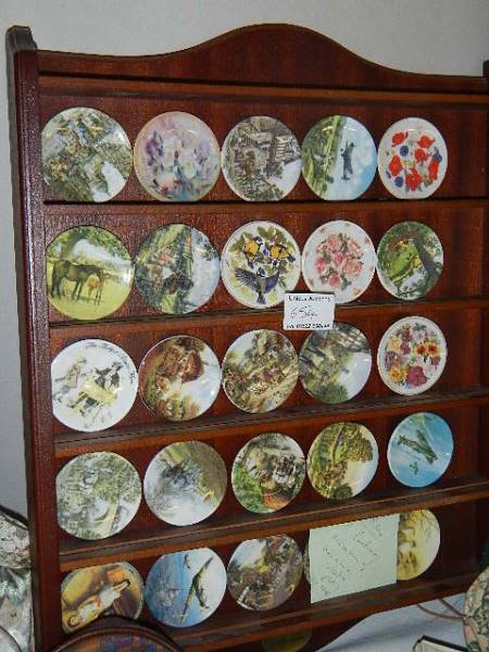 A centenary collection of miniature collector's plates on rack.