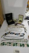 A mixed lot of necklaces, brooches etc.,