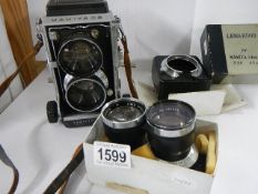 A Mamiya C3 professional camera, a boxed Mamiya lens hood and Mamiya Sekor lenses.