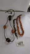 A natural amber necklace in a cube design, a further necklace and a tiger eye stone bracelet.