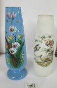 Two hand painted glass vases:- 1 blue with floral pattern and 1 opaque with birds.