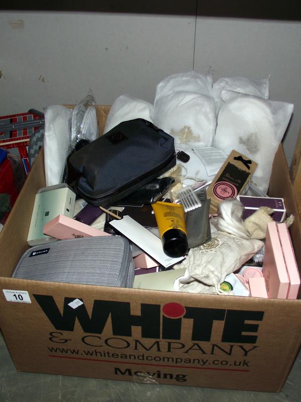 A box full of complimentary items from hotels including slippers, shampoo, conditioner, cotton