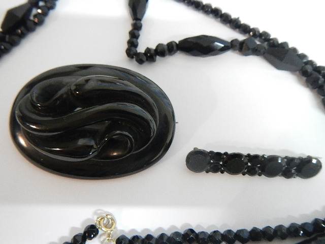 Two black Whitby jet style brooches and a black necklace. - Image 2 of 5