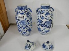 A pair of Chinese blue and white lidded vases (both lids a/f).