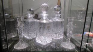 Three cut glass decanters and a pair of glass candlesticks