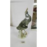 A Royal Dux figure of a heron with a fish in its mouth, in good condition.