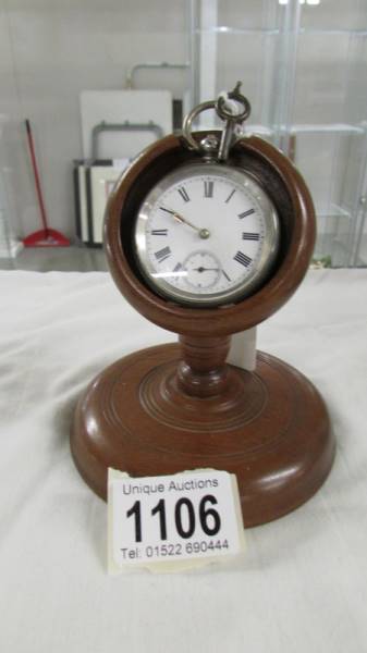 A silver pocket watch on stand (not working).