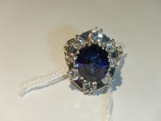 An 18ct white gold ring set large sapphire surrounded by 8 small diamonds, size N.