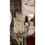 A bisque porcelain figure of a small girl seated and another figure 'Papa's Darling'.