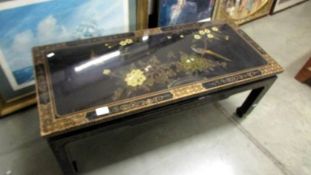 A black lacquered coffee table decorated with birds. COLLECT ONLY.