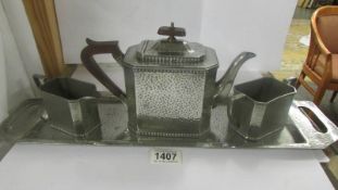 An arts and crafts pewter tea set on tray by Craftsman Pewter, Sheffield, tray 60.5 x 14.5 cm.