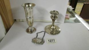 A silver candle holder, silver spill vase and silver sherry label.