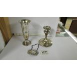 A silver candle holder, silver spill vase and silver sherry label.