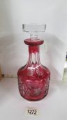 A red overlaid cut glass decanter.