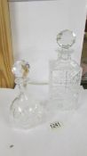 A heavy cut glass decanter and a smaller example.