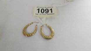 A pair of gold hoop earrings, 1 gram.