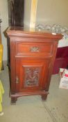 A mahogany cupboard with carved door and side panels, 95 x 56 x 56 cm. COLLECT ONLY.