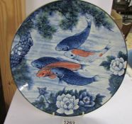 A fish decorated charger, 31 cm diameter.