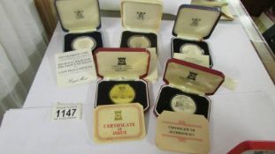 Five cased silver commemorative crowns with certificates.