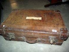 A large early leather suitcase (missing brass plaque on lid)