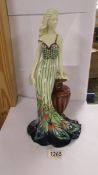 An Old Tupton ware figure of a woman leaning on an urn,