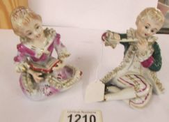 A pair of continental porcelain seated figures.