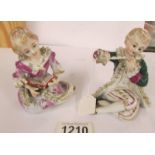 A pair of continental porcelain seated figures.