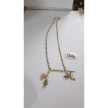 A long 9ct gold chain with four gold charms, 19 grams.