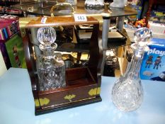 A tantalus with key but missing a decanter, plus one other decanter