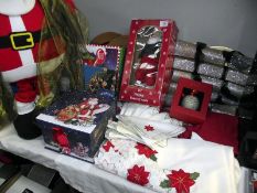 A selection of Christmas items including tablecloth, napkins, singing Santa, Christmas box etc
