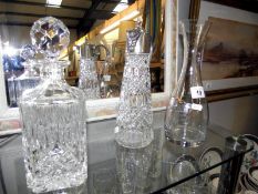 A decanter, silver plate and glass lidded jug and a carafe