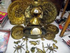 A selection of brass ware including wall plaques, oil lamp, trivet, planter and animals