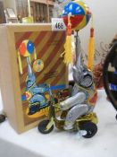 A boxed tin plate clockwork elephant on a bicycle.