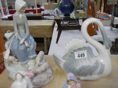 A Lladro style figure of a girl with pigs and a NAO swan.