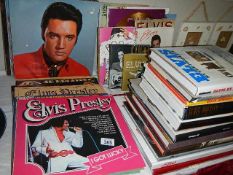 A quantity of Elvis LP records and hard back books.