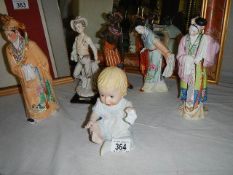 Three Japanese figures, an African figure, a boy and a baby figures.