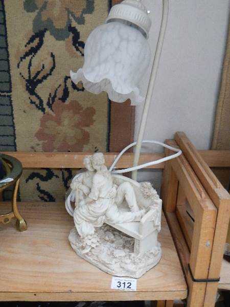 A table lamp with lover's on bench base.